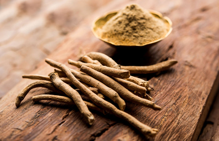 Ashwagandha roots and ground ashwagandha on a wooden surface