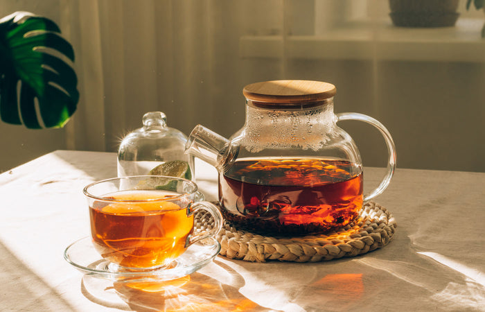 Glass teapot and cup with tea on a table