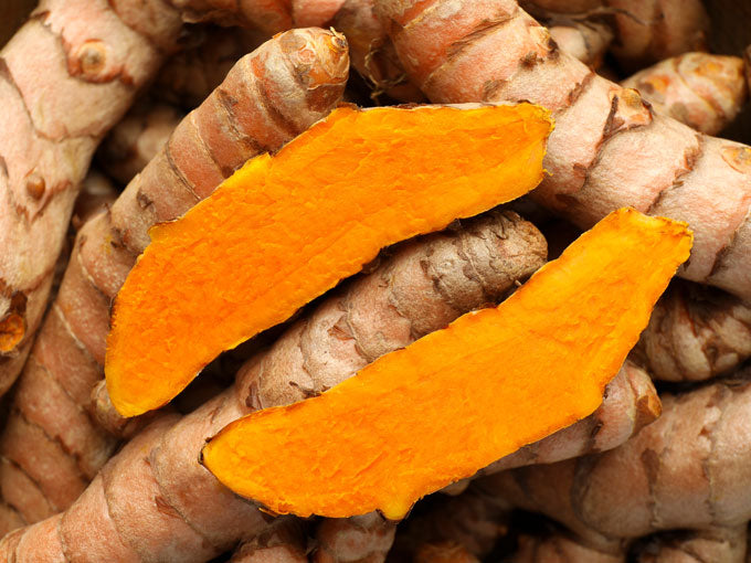 Turmeric roots with sliced pieces on top
